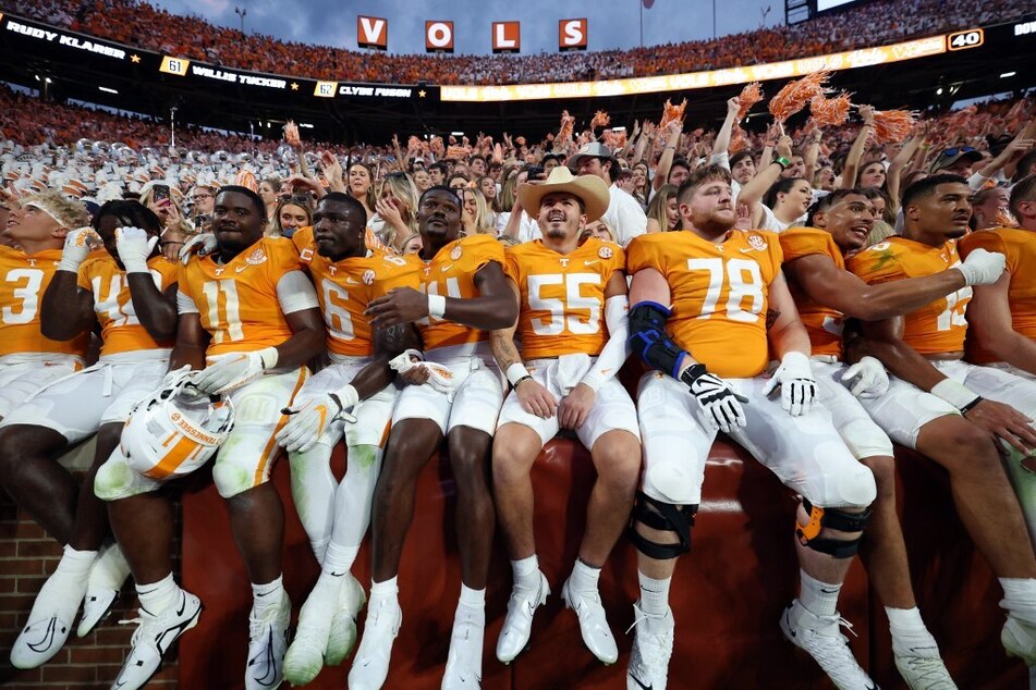 The Tennessee Volunteers team celebrates in the stands with the fans after a win against the Florida Gators at Neyland Stadium.