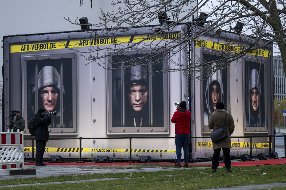Vor dem Bundeskanzleramt in Berlin zeigen Fotomontagen Politiker der AfD hinter Gitterstäben.