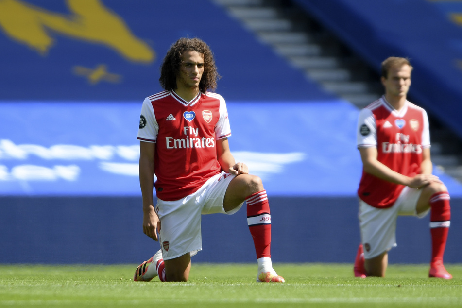 Matteo Guendouzi (l) kniet vor Anpfiff auf dem Rasen.