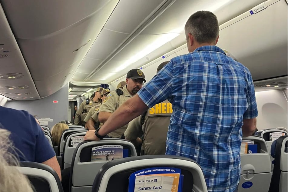Nach der Landung in Madison führten Polizeibeamte den Unruhestifter aus dem Flugzeug.