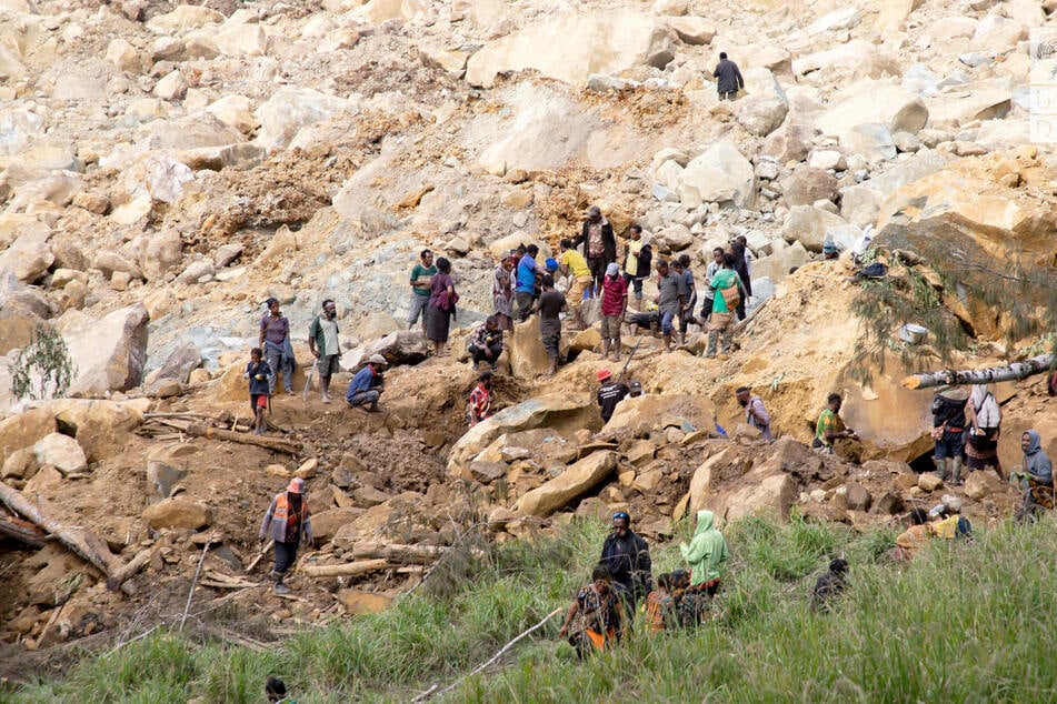 People clear an area at the site of a landslide in Yambali village, Enga Province, Papua New Guinea.