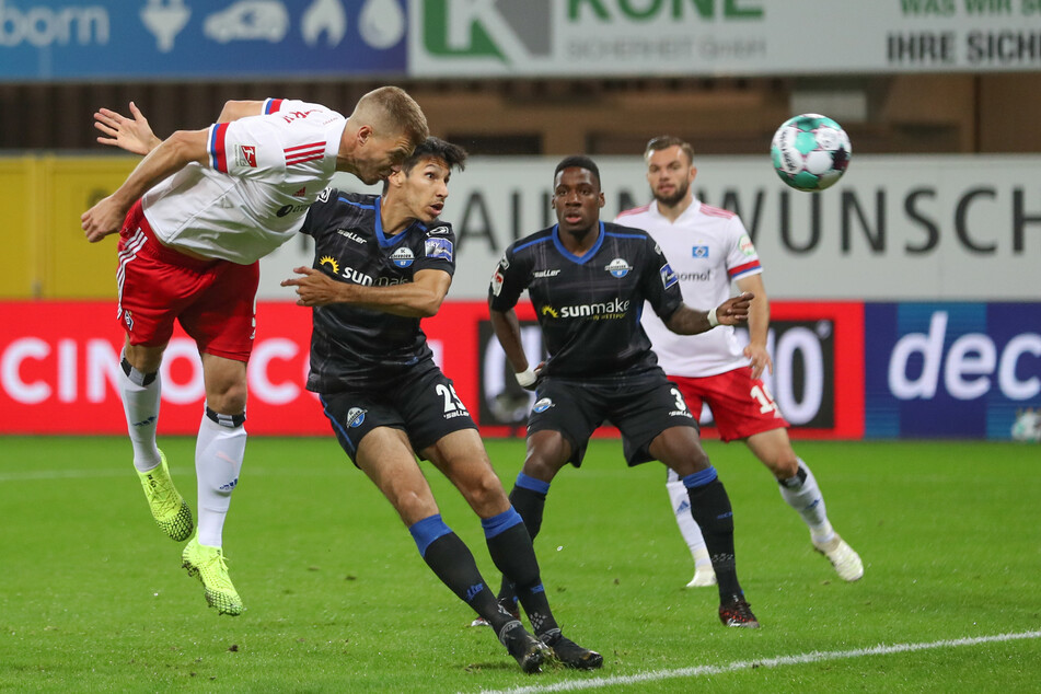 Simon Terodde (32, l.) aus Hamburg köpft auf das Tor. Die Paderborner Marcel Correia (31, 2.v.l.) und Frederic Ananou (23, 2.v.r.) können den Kopfball nicht verhindern.