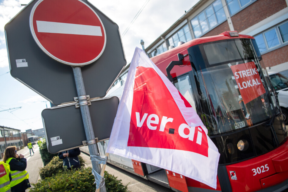 Eine Verdi-Flagge hängt vor einer Straßenbahn der Bremer Straßenbahn AG (BSAG). Seit Dienstag wird in der Hansestadt gestreikt. (Archivfoto)