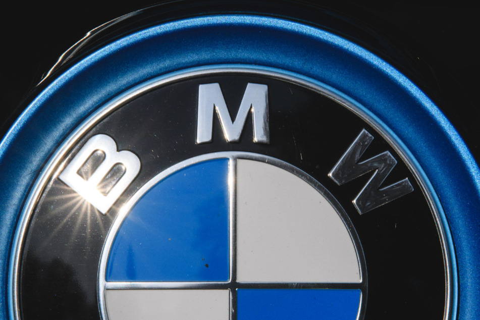Die Sonne spiegelt sich in einem Logo des Autoherstellers BMW.