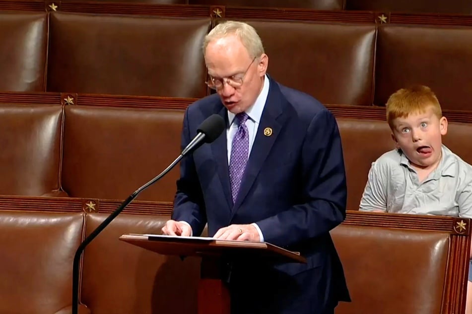 Tennessee Congressman John Rose (c.) passionately defended Donald Trump during a recent House meeting, while his young son, Guy (r.), made faces behind him.