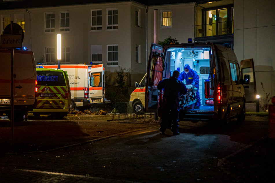 Großeinsatz in Mügeln: Mehrere Rettungskräfte in Schutzanzügen brachten gestern drei infizierte Bewohner in ein Krankenhaus.