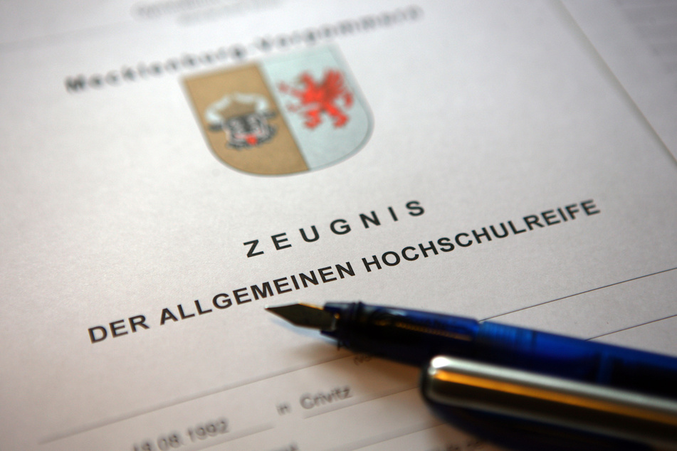 Ein Füllfederhalter liegt auf einem Abiturzeugnis.