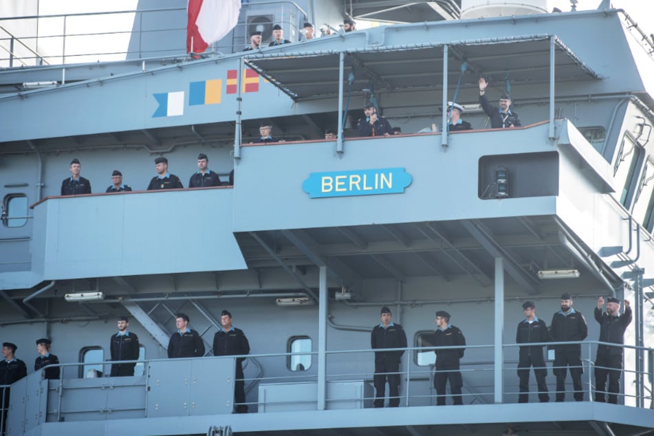 Besatzungsmitglieder der "Berlin" stehen an Deck und winken beim Einlaufen den wartenden Angehörigen zu.