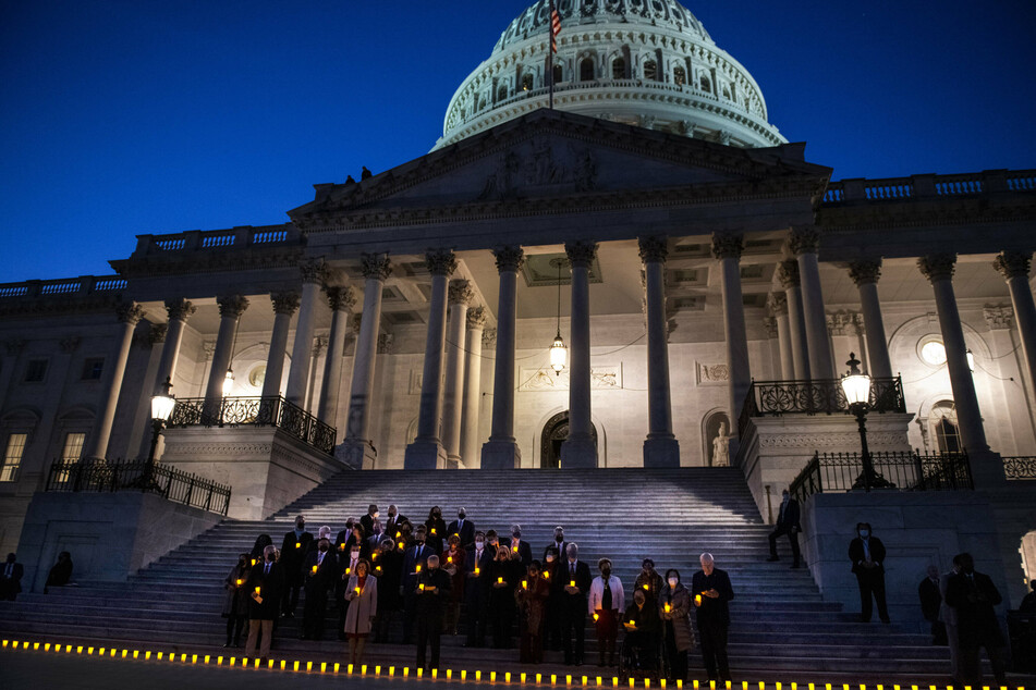 Congress held a moment of silence in front of the Capitol, marking the grim milestone with lit candles.