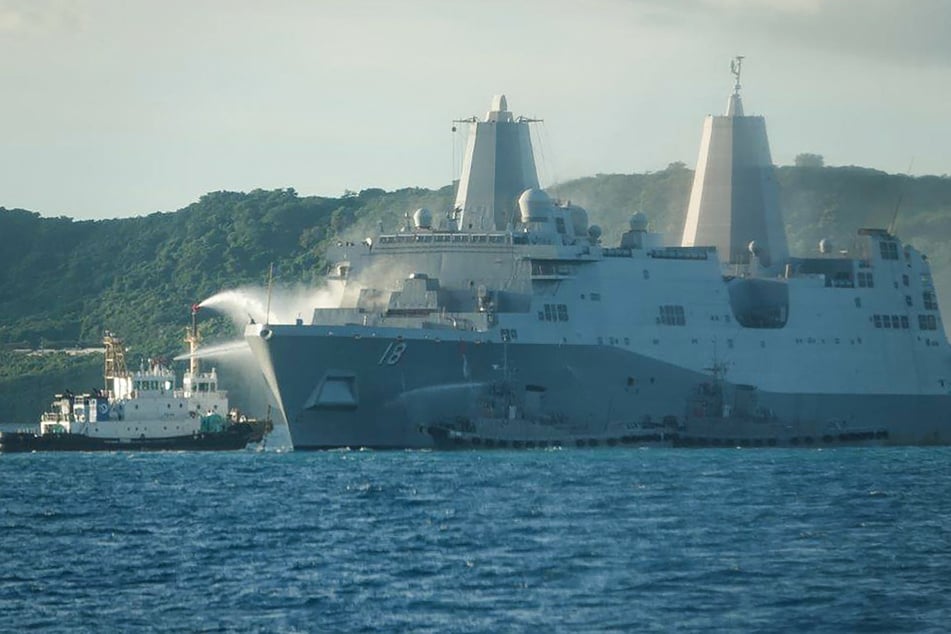 Smoke rises from the US Navy vessel USS New Orleans as water is sprayed to help put out the fire, off the coast near White Beach on the island of Okinawa.