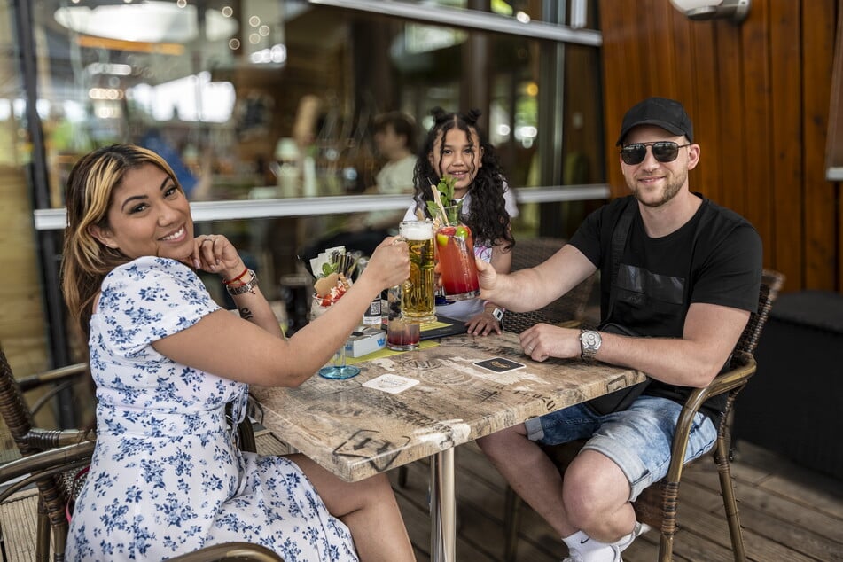 Amliv (33, l.), Nicole (8) und Mate Douarte-Csak (34) genießen das schöne Wetter auf der Terrasse der Pelzmühle.