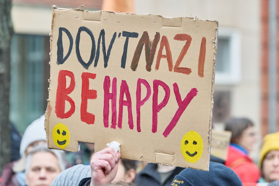 Zahlreiche Demonstranten halten Plakate in die Luft.