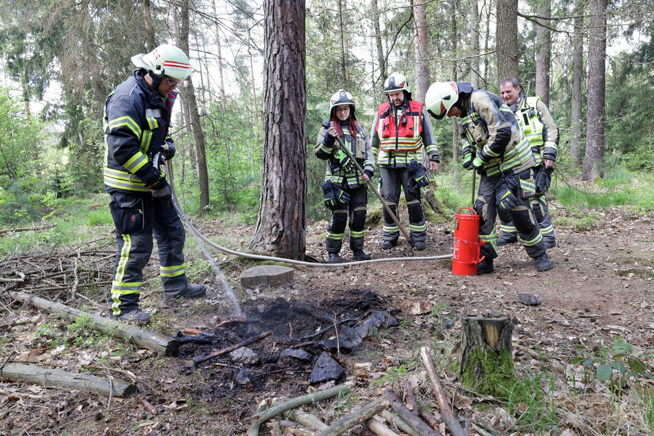 Die Kameraden löschen den Brand mit einer Kübelspritze.