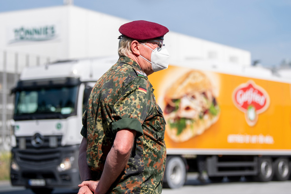 Ein Soldat der Bundeswehr steht vor dem Gebäude der Fleischfabrik Tönnies. Die Bundeswehr soll bei dem Testverfahren der Mitarbeiter auf den Coronavirus unterstützen.