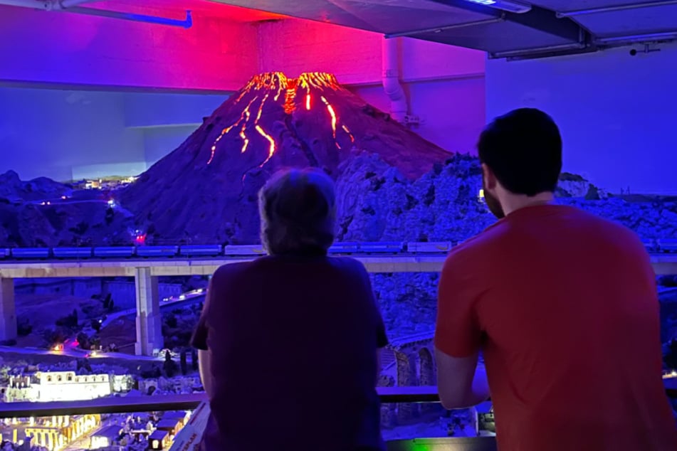 Zwei Besucher verfolgen den Ausbruch des Vesuvs. Der Vulkan bricht im "Miniatur Wunderland" regelmäßig bei Einbruch der Nacht aus.