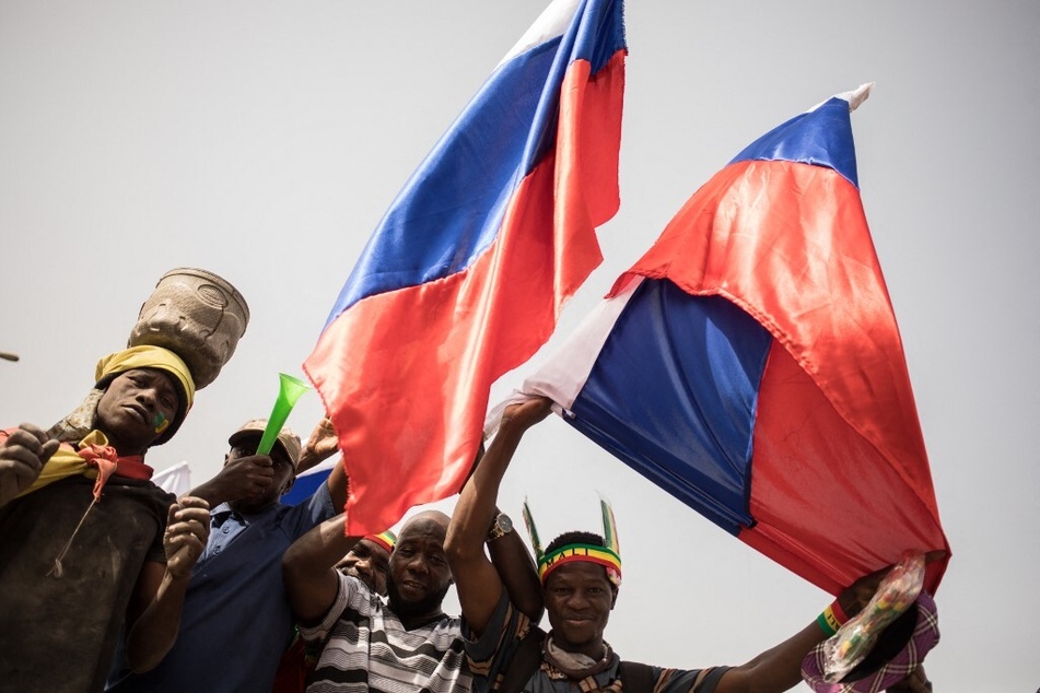 Protesters wave Russian flags during a demonstration organized by the pan-Africanst platform Yerewolo to celebrate France's announcement to withdraw troops from Mali, on February 19, 2022.
