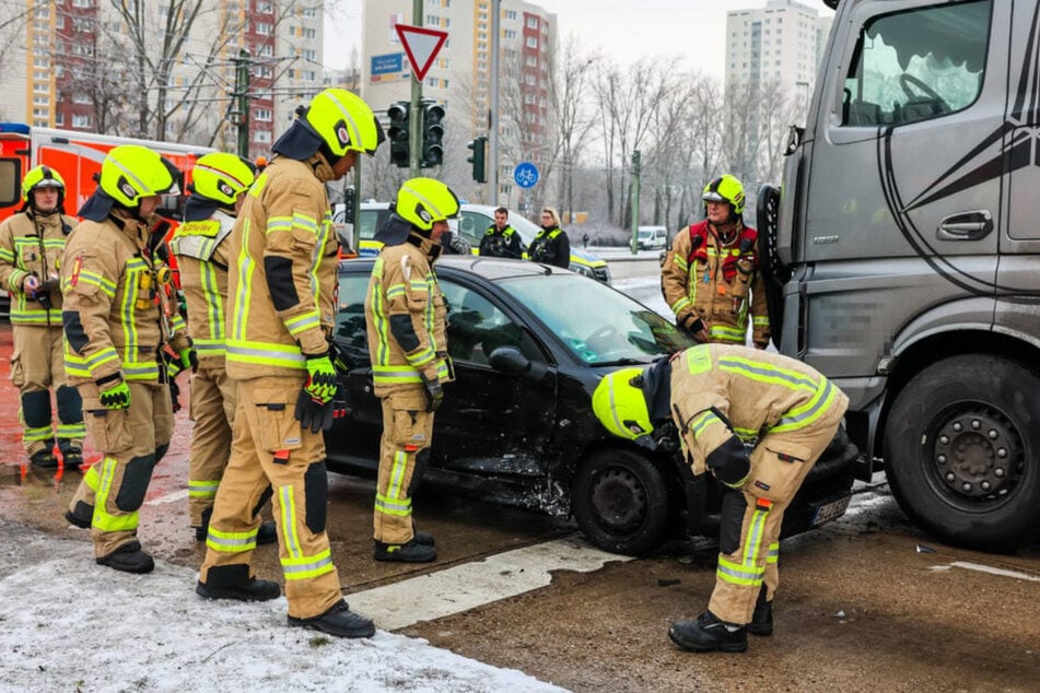 Die Feuerwehr schaut sich das Unfallfahrzeug genau an.
