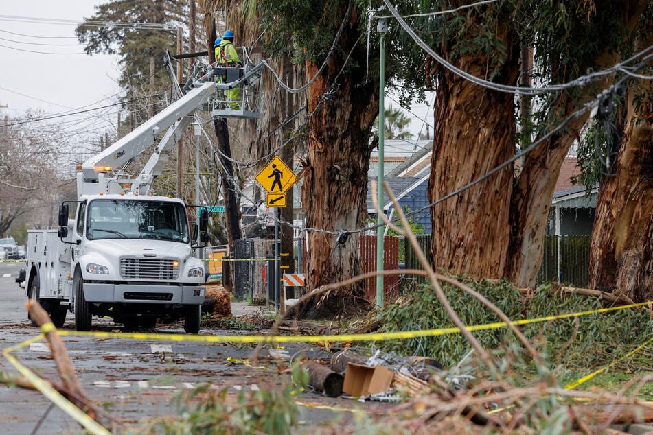 A Sacramento Municipal Utility District crew repairs downed power lines following storms in California.