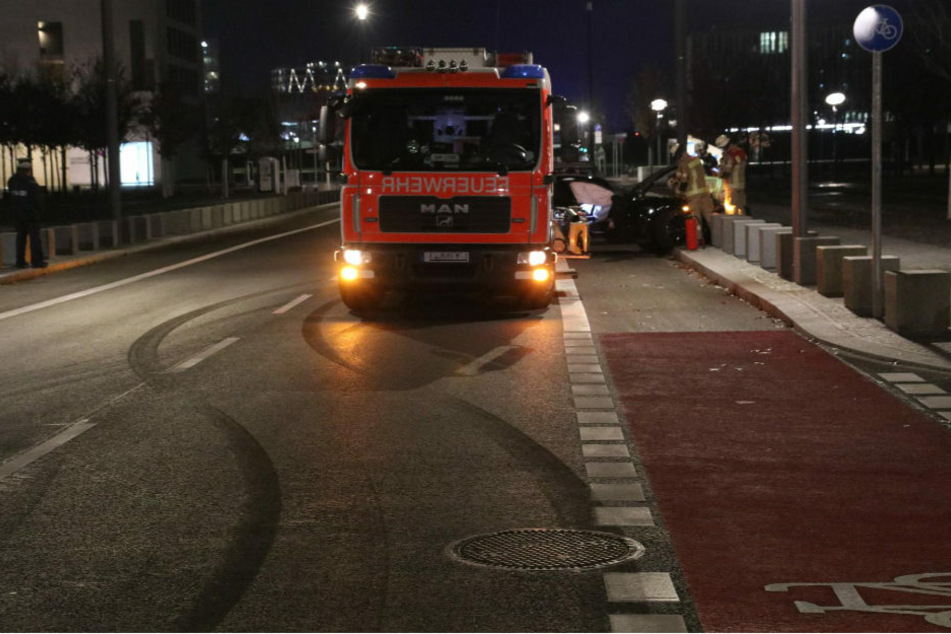 Feuerwehrleute sichern den Unfallwagen. Auf der Straße ist eindeutig die Bremsspur zu erkennen, die der Porsche dort hinterlassen hat.
