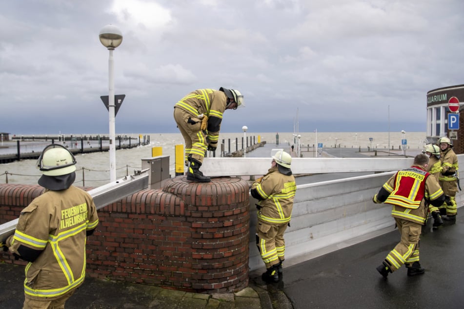 Feuerwehrleute müssen kräftig anpacken und die Deichschart zum Helgolandkai in Wilhelmshaven schließen.