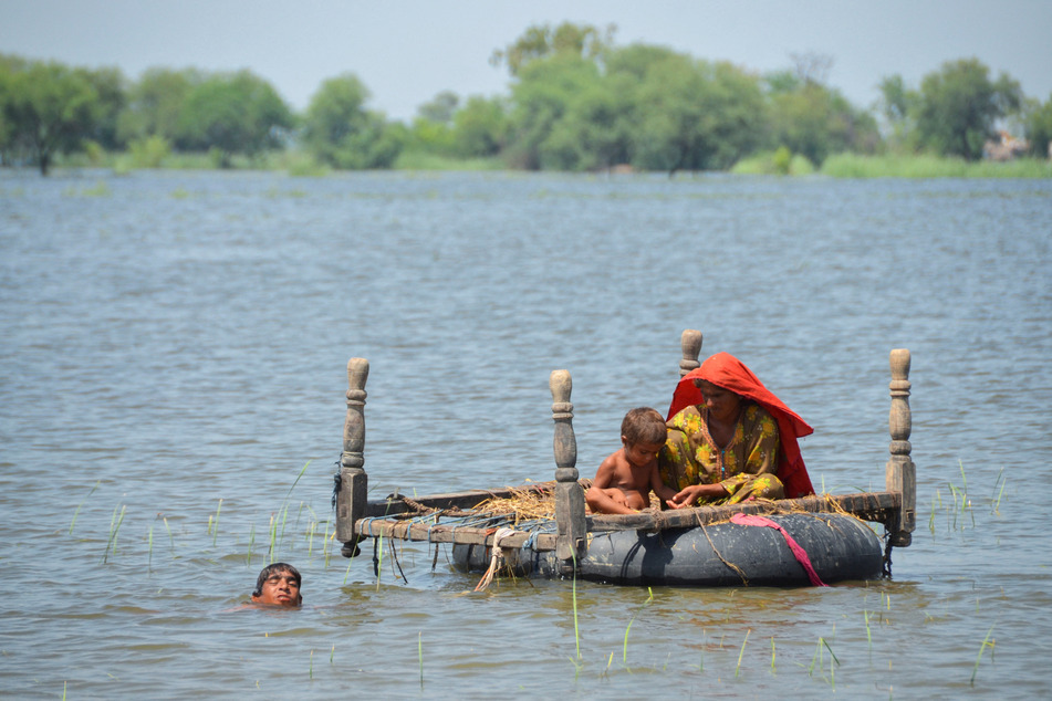 Flood victims in Pakistan use an inflatable tube following heavy downpours during the monsoon season.