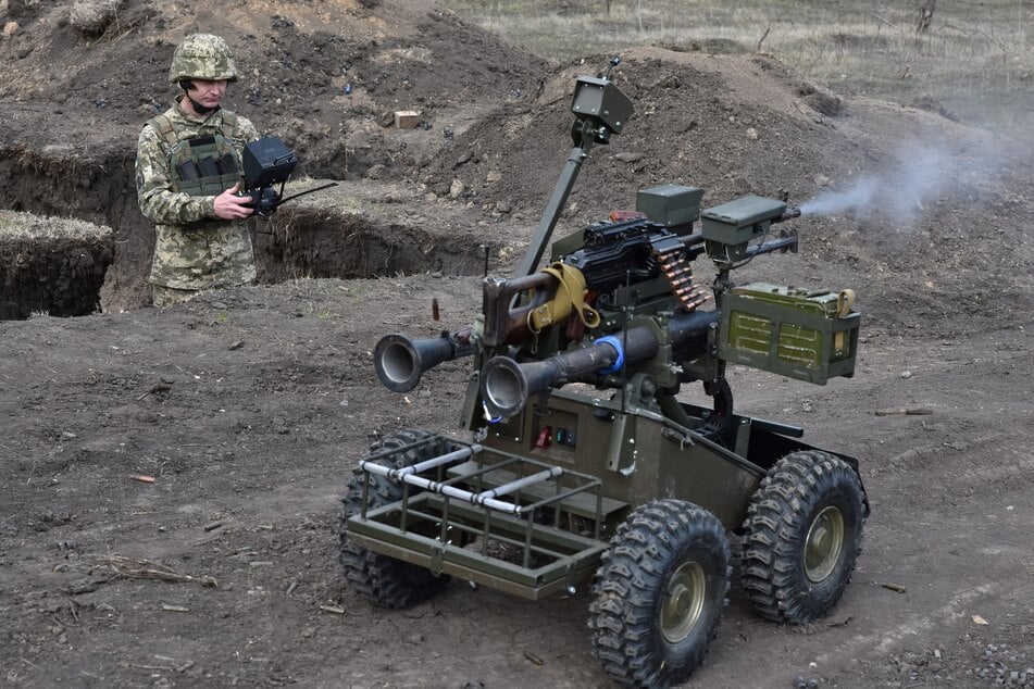 Ukrainische Soldaten überprüfen eine unbemanntes Landfahrzeug, ein sogenanntes UGV.