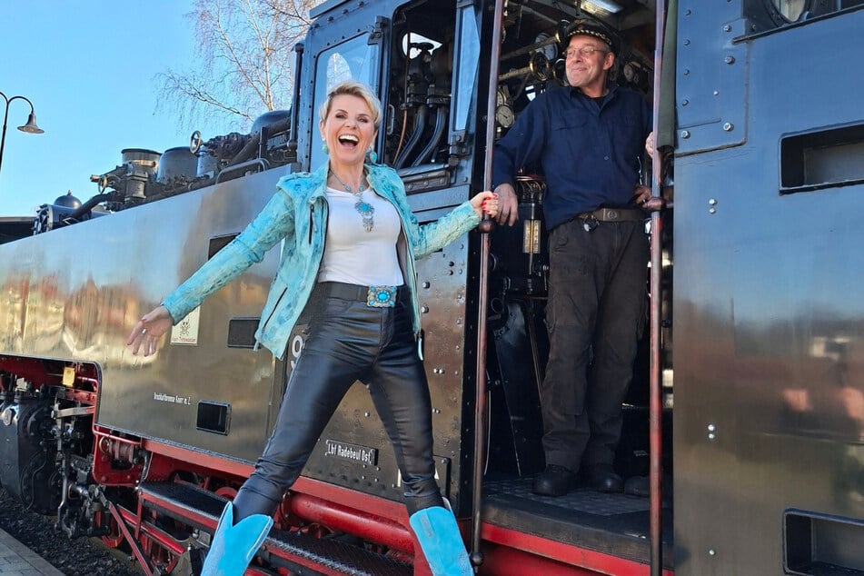 Linda Feller lässt sich vom Lokführer in die Dampflok des Lößnitzdackels helfen.