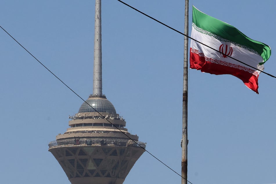 The Iranian flag flutters near the Milad Tower in Tehran on May 25, 2026.