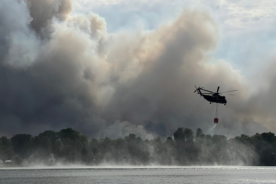Mit Löschhubschraubern und Wasser aus dem Seddiner See versuchen die Feuerwehrleute den Waldbrand unter Kontrolle zu bringen.
