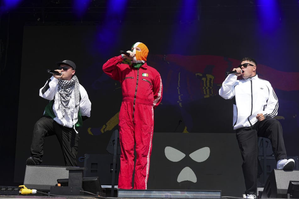 Das irische Hip-Hop-Trio Kneecap gilt als starker Kritiker der britischen Regierung. Sie fordern etwa eine Wiedervereinigung Irlands und ein Ende der Kontrolle über den Norden der Insel.