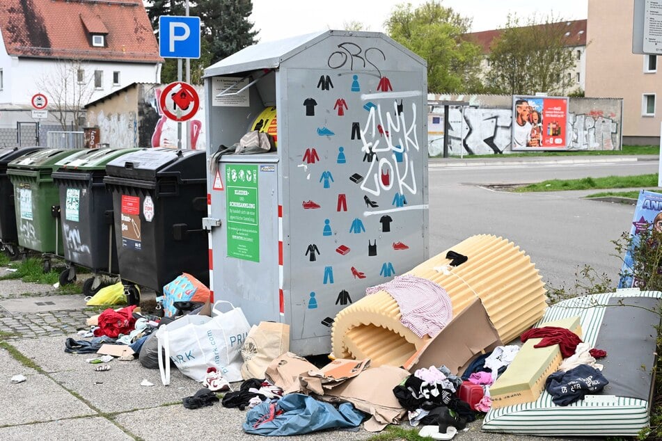 In der Essener Straße türmen sich Altkleider und anderer Sperrmüll neben dem Container.