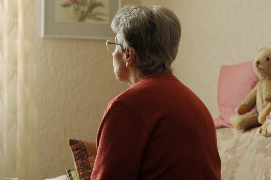 Eine alte Frau sitzt bei sich zu Hause auf ihrem Sofa (Symbolbild).