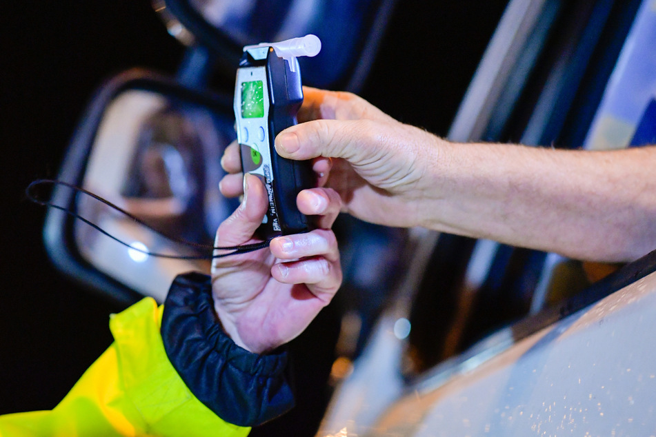 Polizisten reichen einem Fahrer ein Alkoholmessgerät. In Erfurt zogen die Beamten einen 35-Jährigen mit 3,5 Promille im Blut aus dem Verkehr. (Symbolbild)