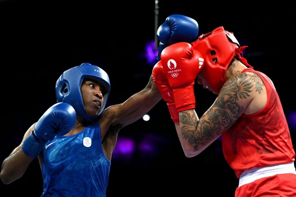 The Olympic Refugee Team's Cindy Winner Djankeu Ngamba (l.) punches Canada's Tammara Amanda Thibeault during their Paris Games matchup.