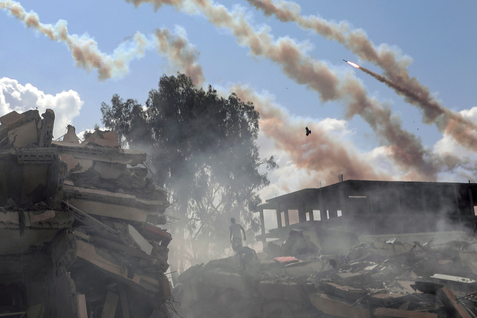 Raketen aus dem Gazastreifen werden über zerstörte Gebäude hinweg auf Israel abgefeuert.