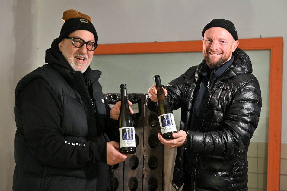 Die Weinfreunde Andreas Müller (53, l.) und Francesco Karnapp (39) laden zum "Austrinken" ein, um den restlichen Glühwein vom Weihnachtsmarkt zu vertrinken.