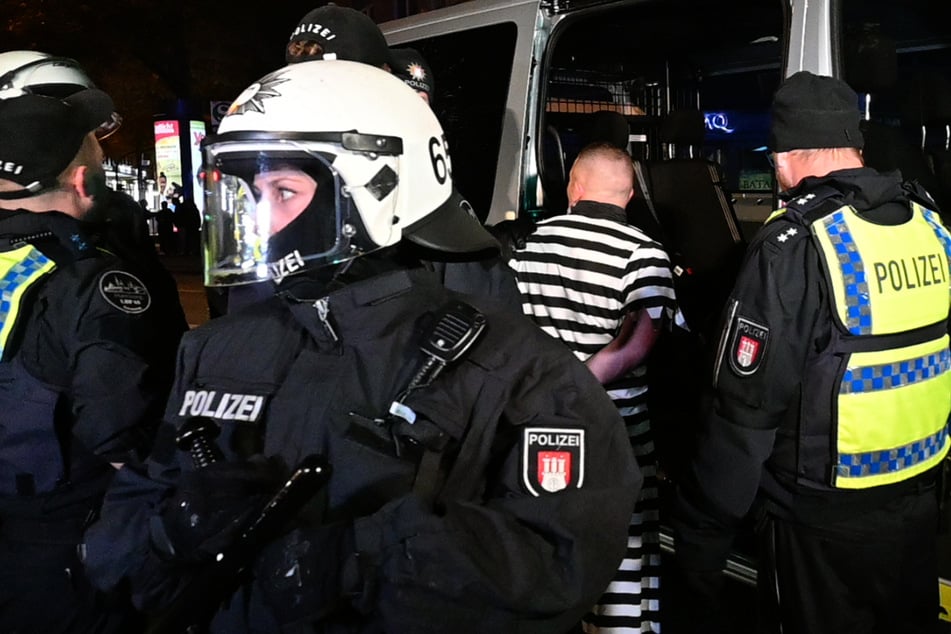 Polizisten nehmen einen als Sträfling verkleideten Mann in Hamburg-Harburg fest.