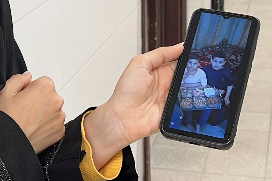 A Palestinian woman shows on her mobile phone the children of the Al-Najjar family who were killed in an Israeli airstrike, in Khan Younis in the southern Gaza Strip.