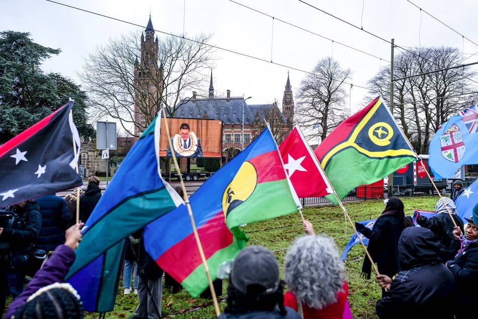 Protesters gather outside the International Court of Justice during hearings examining the obligations countries have in the fight against climate change.
