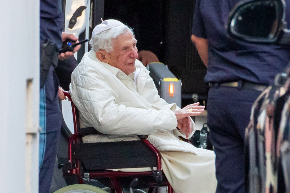 Der emeritierte Papst Benedikt XVI (93) wird mit einem Rollstuhl in einen Bus geschoben.