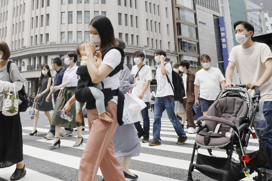 Japan, Tokio: Passanten gehen im Einkausfviertel Ginza über einen Zebrastreifen.