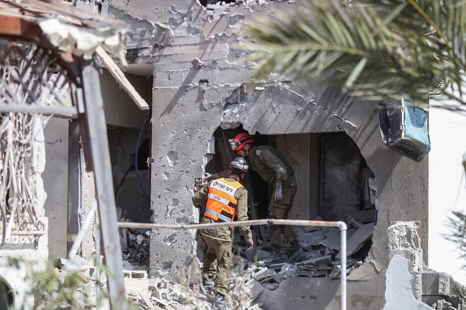 Rettungskräfte untersuchen ein beschädigtes Gebäude in Ashkelon, nachdem es von Raketen getroffen wurde, die aus dem Gazastreifen abgefeuert wurden.