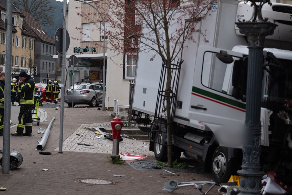 Der Unfall-Lkw sowie zahlreiche Trümmerteile liegen auf der Straße verteilt.