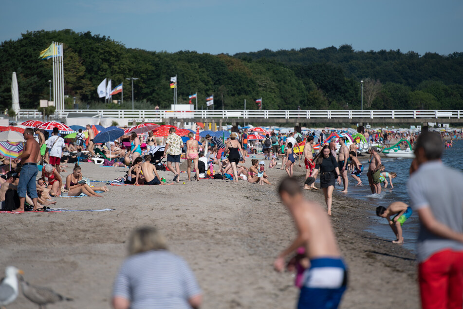 Zahlreiche Menschen sind schon in den Morgenstunden am Timmendorfer Ostseestrand unterwegs