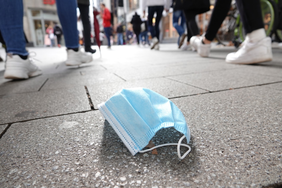 Eine Corona-Maske liegt in Köln auf der Straße.