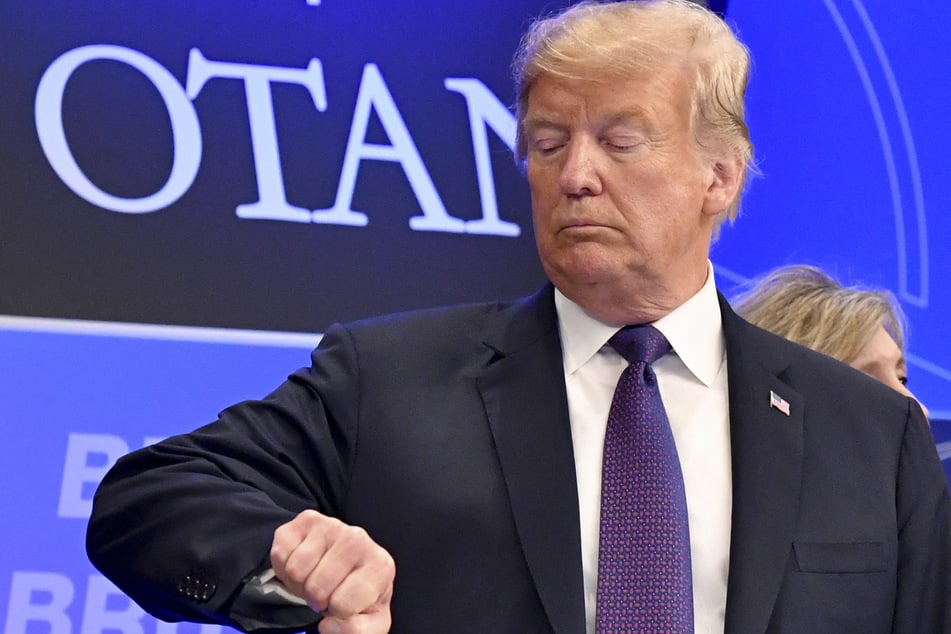 Donald Trump checks time prior to a dinner of leaders at the Art and History Museum at the Park Cinquantenaire in Brussels on July 11, 2018.