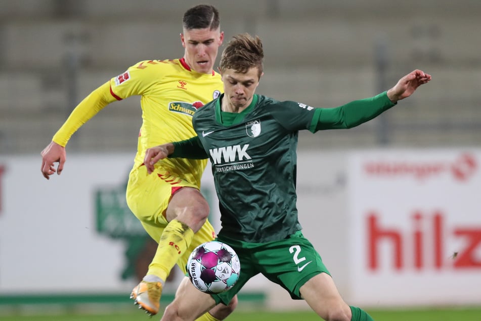 Freiburg gegen Augsburg, Gelb gegen Grün, SCF-Torschütze Roland Sallai (23, l.) gegen FCA-Kicker Robert Gumny (22, r.).
