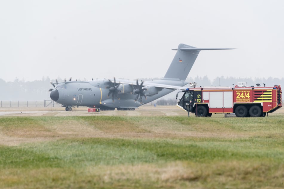 Ein Airbus-Militärtransporter A400M fährt am Fliegerhorst Lagerlechfeld an einem Einsatzfahrzeug der Flughafenfeuerwehr vorüber.