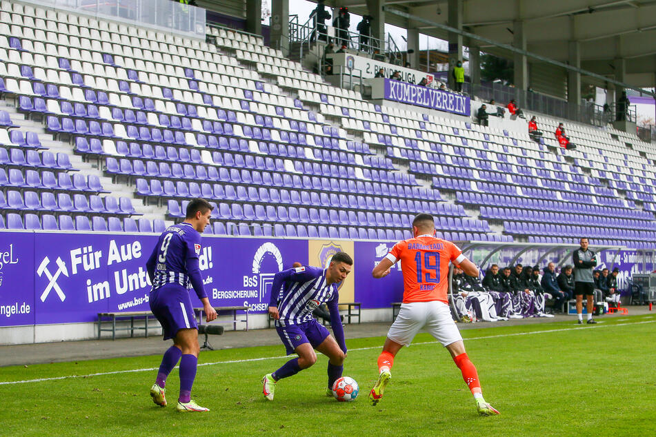 Aue-Mittelfeldmann Antonio Jonjic (l.), John Patrick Strauß (M.) und Darmstadt-Spieler Emir Karic vor leeren Rängen. Das Spiel fand wegen Corona ohne Zuschauer statt.