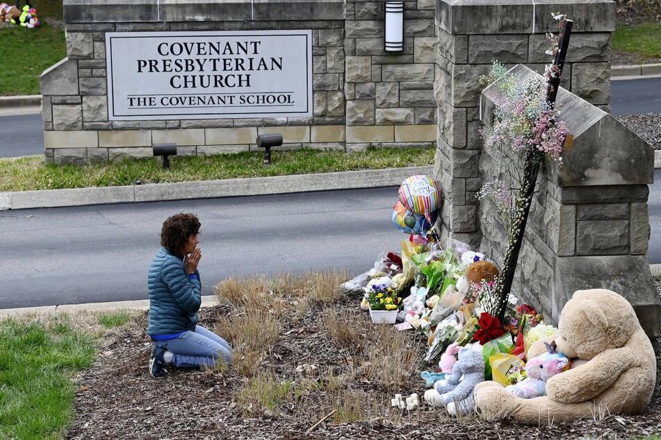 A woman prays in front of a makeshift memorial at the entrance to the Covenant School in Nashville on Tuesday.